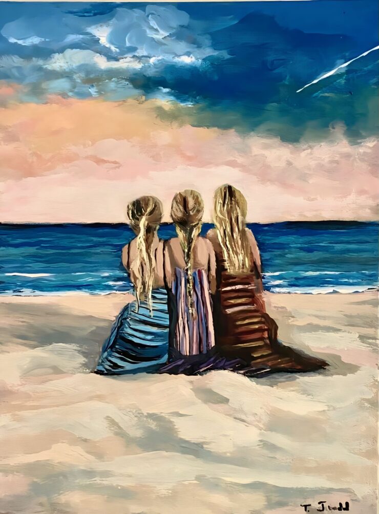 three sisters sitting at the beach, looking at the ocean, from behind.