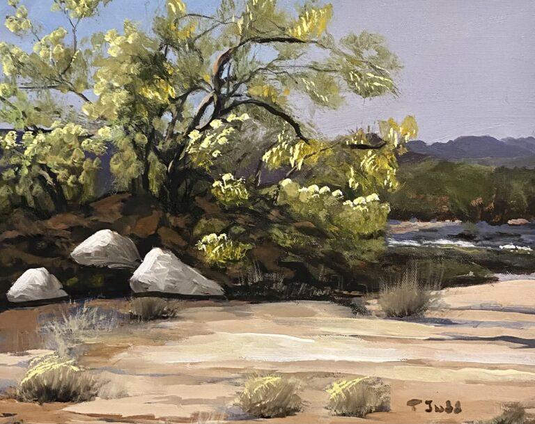 A photo of an original painting by contemporary artist Trese Judd titled "Desert Brush," depicting a desert scene with a smoke tree taking center stage.