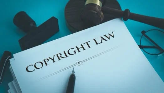 a page that says "copyright law" with a pen resting on it.